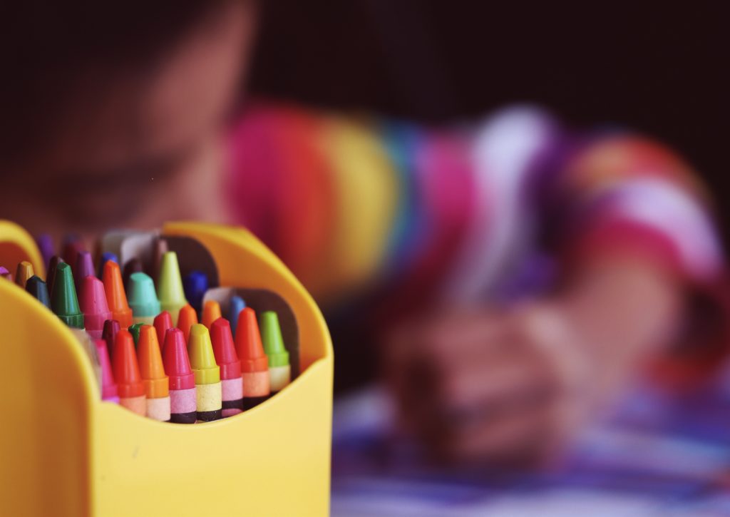 Child with colouring crayons. Creative commons image from Unsplash.